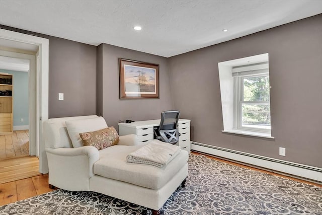 living area with baseboards, recessed lighting, a baseboard radiator, and light wood-type flooring