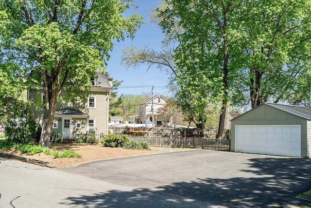 exterior space with board and batten siding, fence, and a detached garage