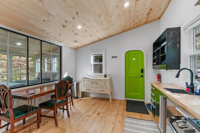 dining area featuring sink, wooden ceiling, light wood-type flooring, lofted ceiling, and ornamental molding