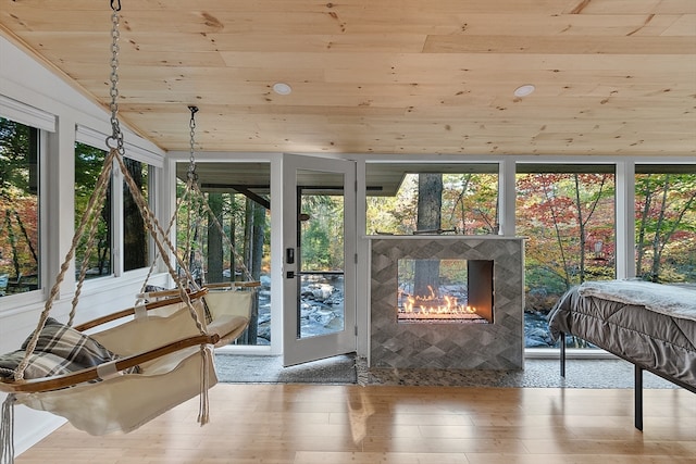 sunroom featuring a fireplace, lofted ceiling, and wood ceiling