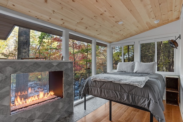 bedroom with light hardwood / wood-style floors, wood ceiling, multiple windows, and vaulted ceiling