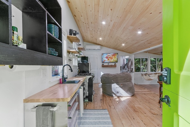 kitchen featuring wooden counters, an AC wall unit, vaulted ceiling, light hardwood / wood-style floors, and wood ceiling