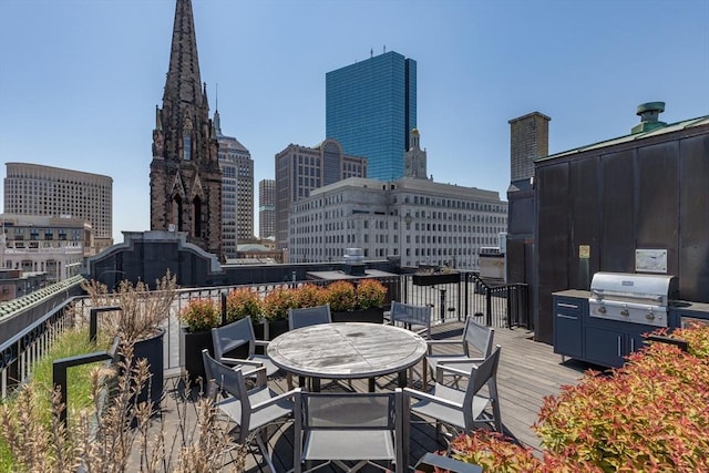 wooden deck with a view of city, area for grilling, and outdoor dining space