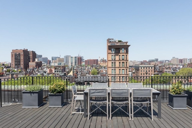 wooden deck featuring a city view and outdoor dining space