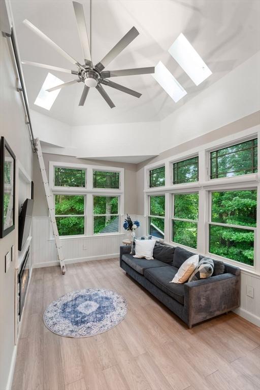 33 Philemon Whale Ln, Sudbury, MA 01776 - living area featuring a skylight, wood finished floors, a ceiling fan, and lofted ceiling
