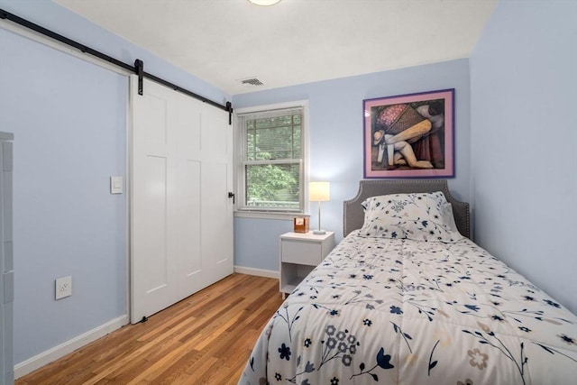 33 Philemon Whale Ln, Sudbury, MA 01776 - bedroom with a barn door, light wood-style flooring, and a closet