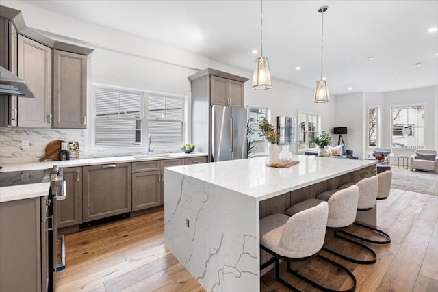 157 Princeton St Unit 1, Boston, MA 02128 - kitchen featuring appliances with stainless steel finishes, a sink, light wood-style flooring, open floor plan, and light stone countertops