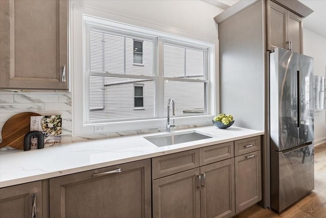 157 Princeton St Unit 1, Boston, MA 02128 - kitchen with freestanding refrigerator, a sink, light wood-style flooring, backsplash, and light stone countertops