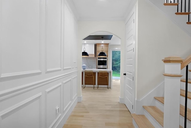293 Cross St, Norwell, MA 02061 - hall with arched walkways, stairway, light wood-style floors, and a decorative wall