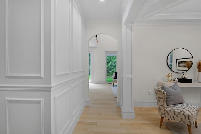 293 Cross St, Norwell, MA 02061 - hallway featuring arched walkways, light wood finished floors, a decorative wall, and crown molding