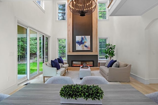 293 Cross St, Norwell, MA 02061 - living room featuring plenty of natural light, a towering ceiling, a chandelier, a fireplace, and arched walkways