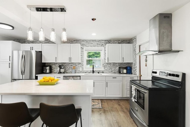 186 Andover St, North Andover, MA 01845 - kitchen featuring stainless steel appliances, wall chimney exhaust hood, backsplash, light wood finished floors, and light countertops