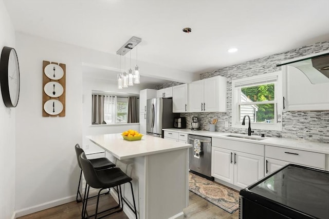 186 Andover St, North Andover, MA 01845 - kitchen featuring appliances with stainless steel finishes, tasteful backsplash, wood finished floors, white cabinetry, and recessed lighting
