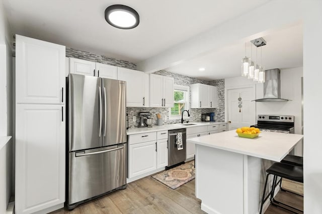 186 Andover St, North Andover, MA 01845 - kitchen with appliances with stainless steel finishes, wall chimney range hood, white cabinets, light wood finished floors, and light countertops