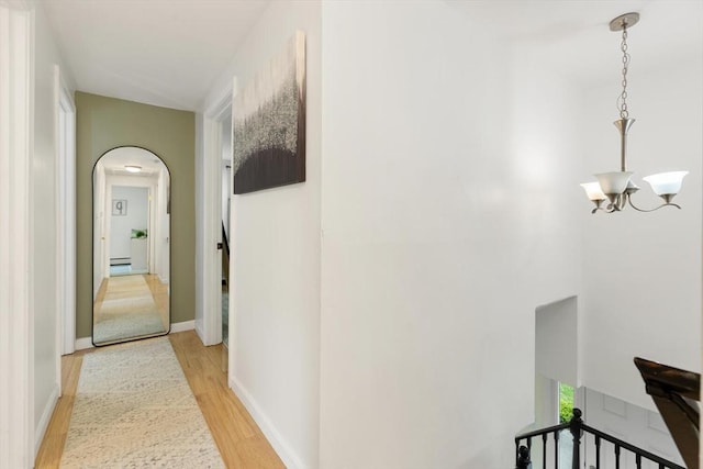 186 Andover St, North Andover, MA 01845 - hall featuring arched walkways, light wood-type flooring, a chandelier, and a baseboard radiator