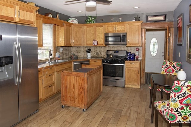 103 Monrovia St, Springfield, MA 01104 - kitchen with appliances with stainless steel finishes, light wood-type flooring, a ceiling fan, a kitchen island, and backsplash