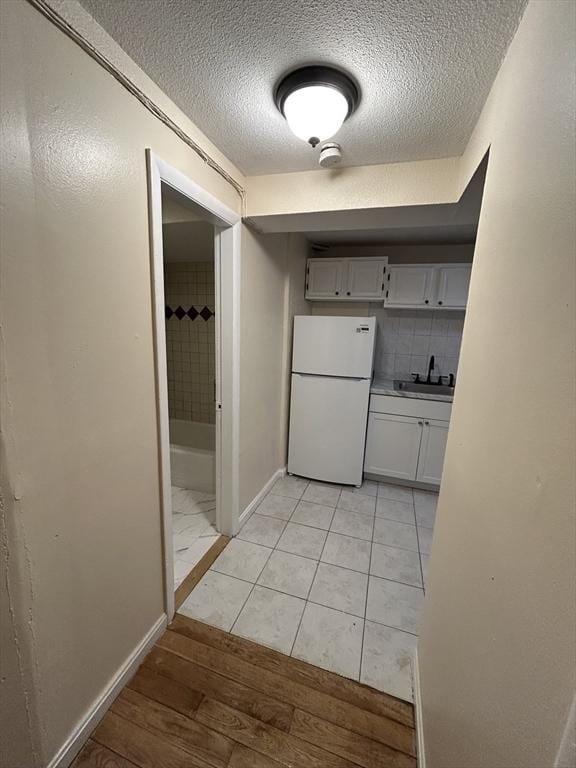 hallway featuring light tile patterned flooring and sink