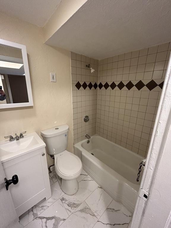 full bathroom featuring tiled shower / bath combo, toilet, a textured ceiling, and vanity