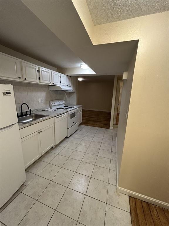 kitchen featuring white cabinetry, sink, white appliances, decorative backsplash, and light tile patterned flooring