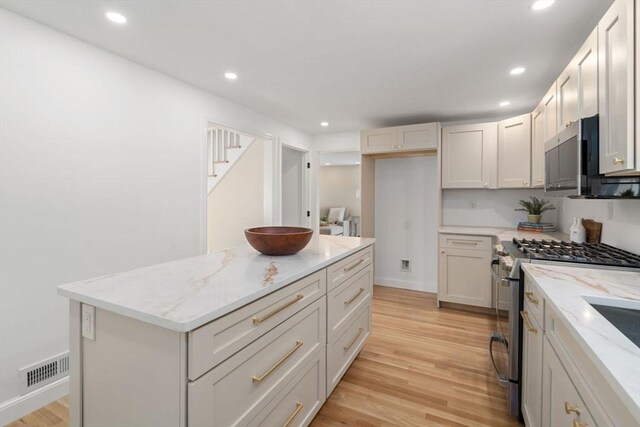 110 Westover Pkwy, Norwood, MA 02062 - kitchen featuring light wood-style floors, visible vents, appliances with stainless steel finishes, and light stone counters