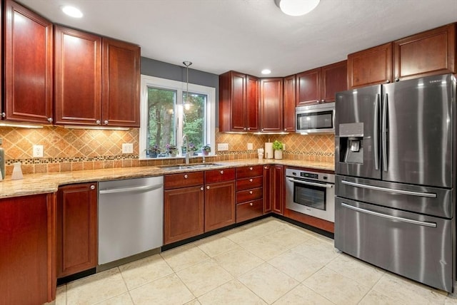 495 Grafton St, Shrewsbury, MA 01545 - kitchen with tasteful backsplash, light stone countertops, stainless steel appliances, a sink, and reddish brown cabinets