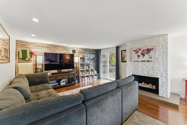 living area with wood finished floors, a fireplace, and recessed lighting