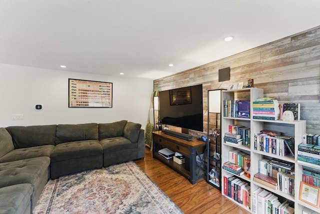 living area with wood finished floors, wooden walls, and recessed lighting