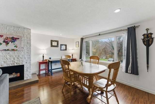 dining room with a textured ceiling, wood finished floors, and baseboards
