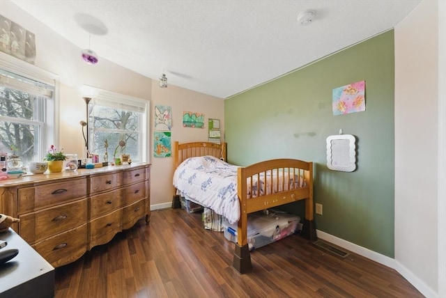 bedroom featuring dark wood-style floors, baseboards, and visible vents