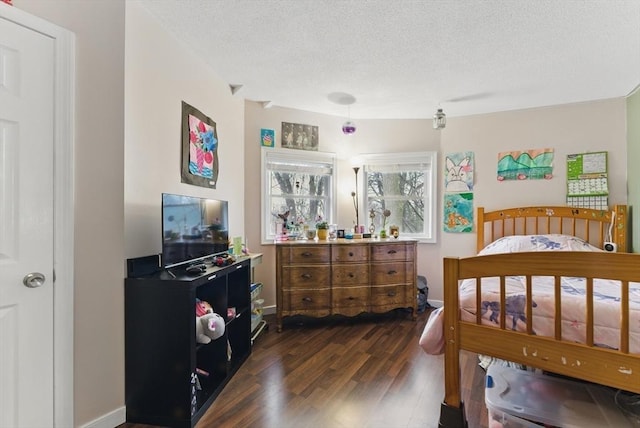 bedroom with dark wood-type flooring, baseboards, and a textured ceiling
