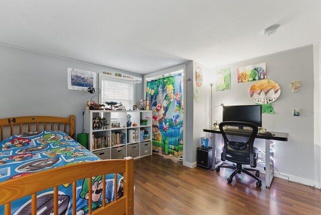bedroom with baseboards and wood finished floors