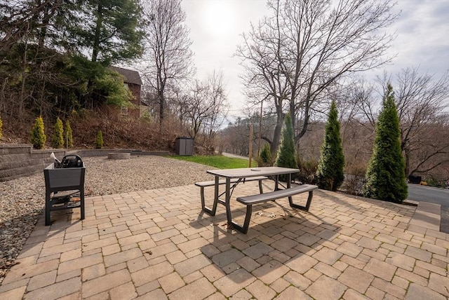 view of patio / terrace featuring a storage shed, an outbuilding, and outdoor dining space