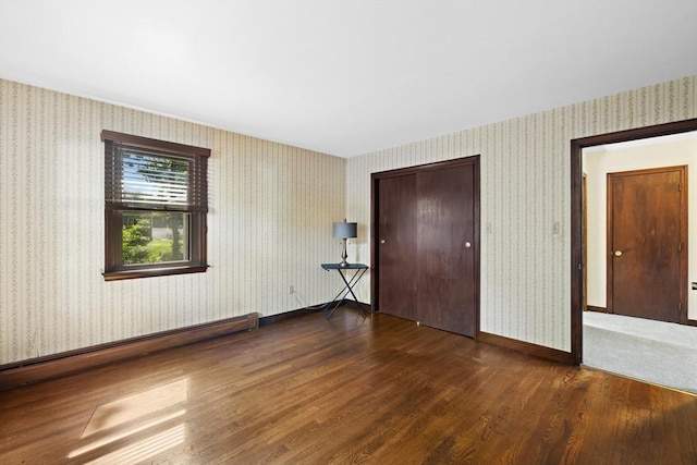 13 Abraham Ave, Freetown, MA 02717 - unfurnished bedroom featuring wood finished floors, a baseboard radiator, wallpapered walls, and a closet