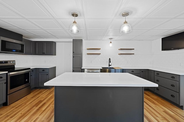 13 Abraham Ave, Freetown, MA 02717 - kitchen with stainless steel appliances, gray cabinetry, decorative backsplash, light wood-type flooring, and an ornate ceiling