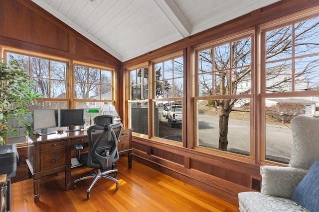 office area with lofted ceiling with beams, wooden walls, wood finished floors, and a wealth of natural light