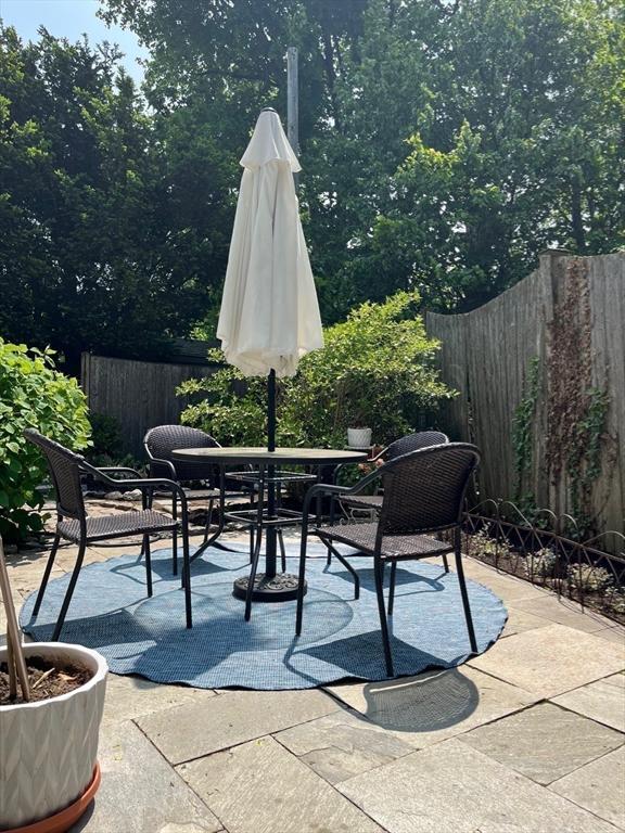 view of patio with outdoor dining space and fence