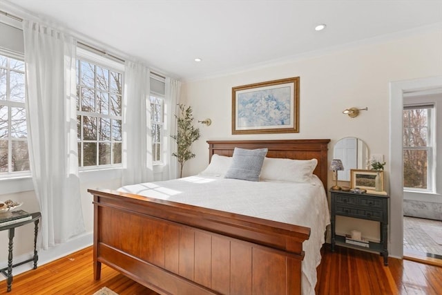 bedroom with recessed lighting, multiple windows, wood finished floors, and ornamental molding