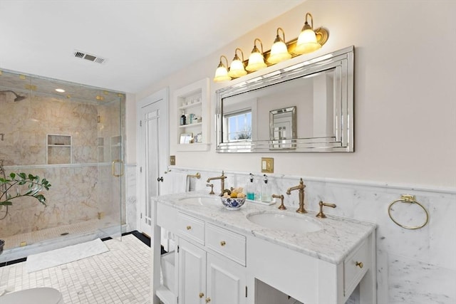 full bathroom featuring a shower stall, wainscoting, visible vents, and a sink