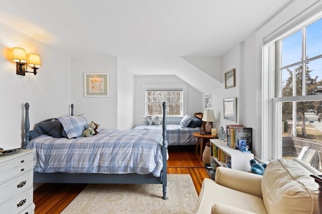 bedroom with wood finished floors and vaulted ceiling