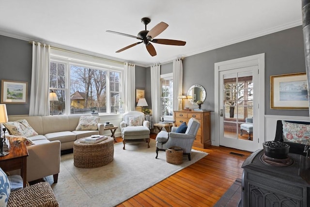 sitting room with wood-type flooring, a ceiling fan, and ornamental molding