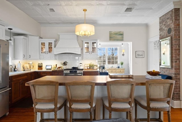 kitchen featuring tasteful backsplash, an ornate ceiling, stainless steel appliances, and custom range hood