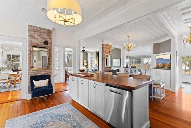 kitchen with white cabinets, wooden counters, hardwood / wood-style flooring, and stainless steel dishwasher