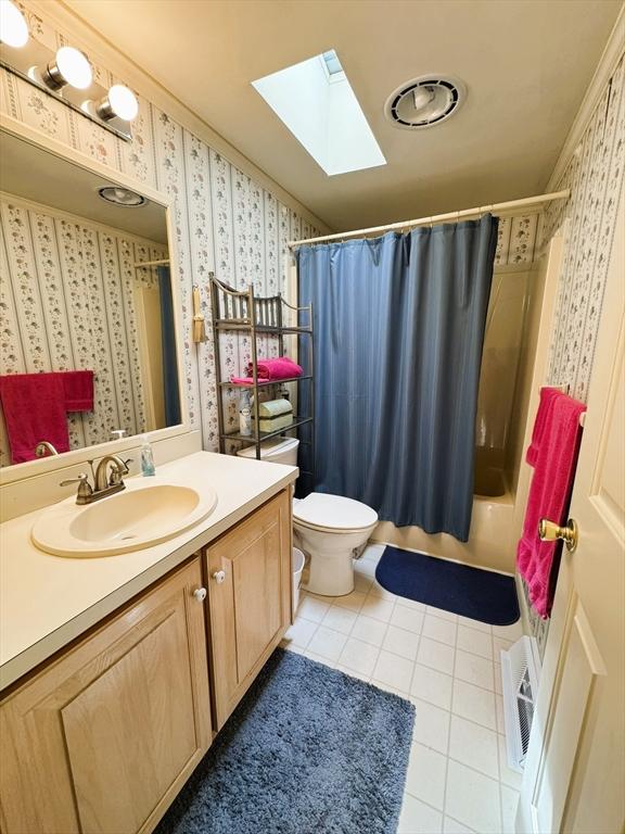 38 Trailwood Dr, Bridgewater, MA 02324 - bathroom featuring wallpapered walls, a skylight, tile patterned flooring, vanity, and shower / bathtub combination with curtain
