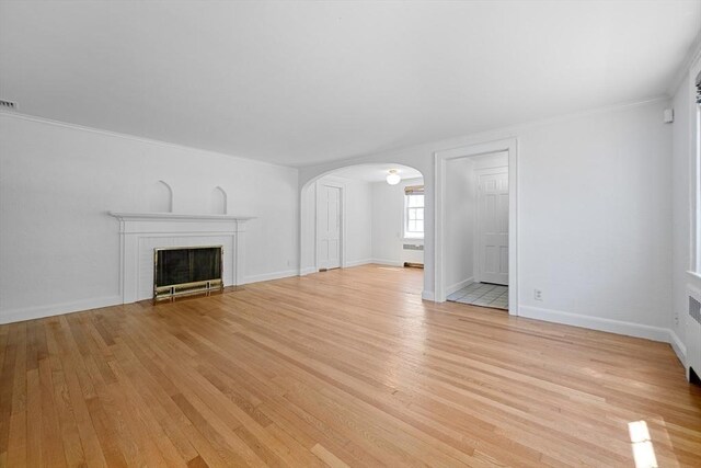 191 Speen, Natick, MA 01760 - unfurnished living room with arched walkways, light wood-style flooring, a fireplace, baseboards, and ornamental molding