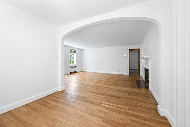 191 Speen, Natick, MA 01760 - unfurnished living room with arched walkways, crown molding, light wood-type flooring, a fireplace with flush hearth, and baseboards