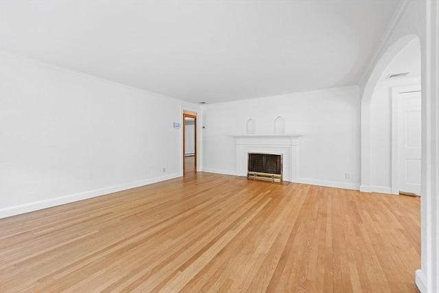 191 Speen, Natick, MA 01760 - unfurnished living room with light wood finished floors, crown molding, a fireplace with flush hearth, arched walkways, and baseboards
