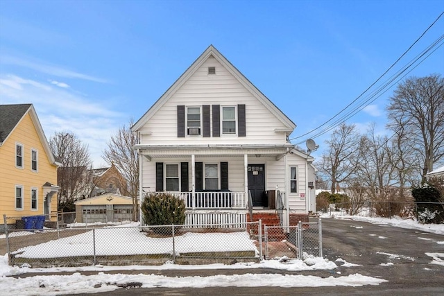 view of front of home featuring a porch, a detached garage, and a fenced front yard