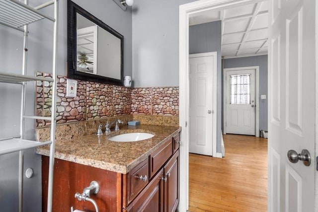 bathroom with backsplash, wood finished floors, and vanity