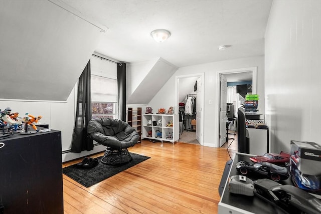 interior space featuring vaulted ceiling, baseboard heating, and wood finished floors