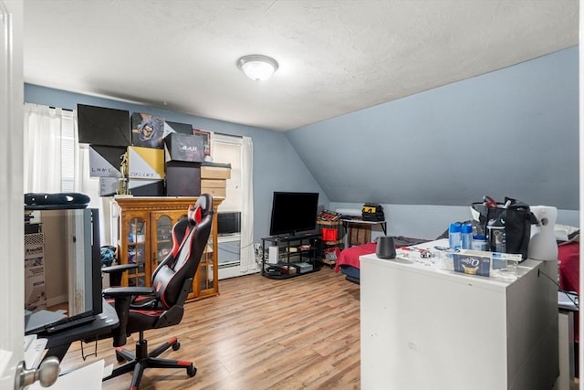 home office featuring vaulted ceiling and wood finished floors